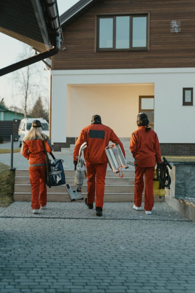 Back View of Workers Walking towards a House